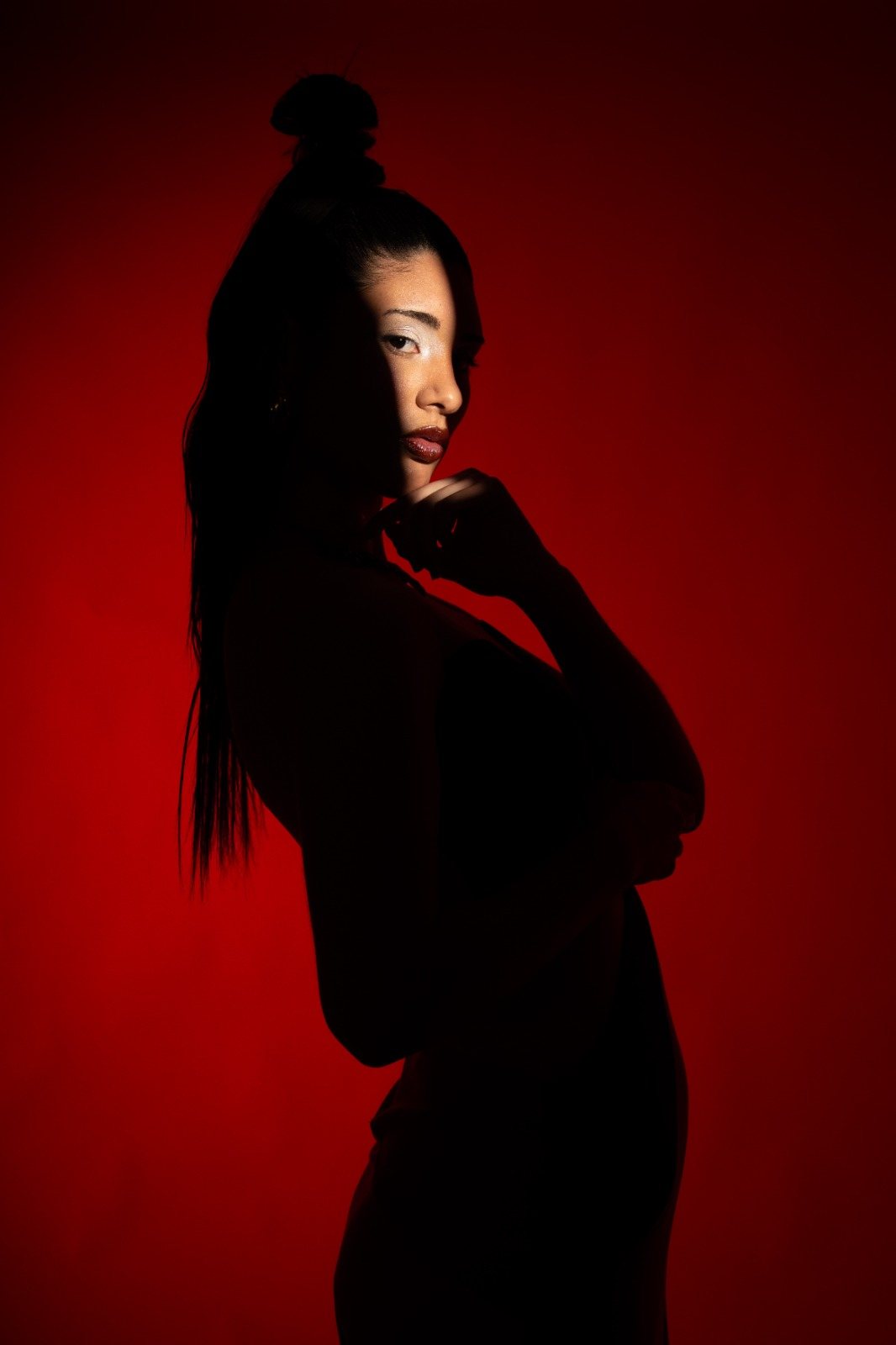 Retrato a contraluz con fondo rojo: ejemplo de cómo cambia una imagen al trabajar luz y contraste